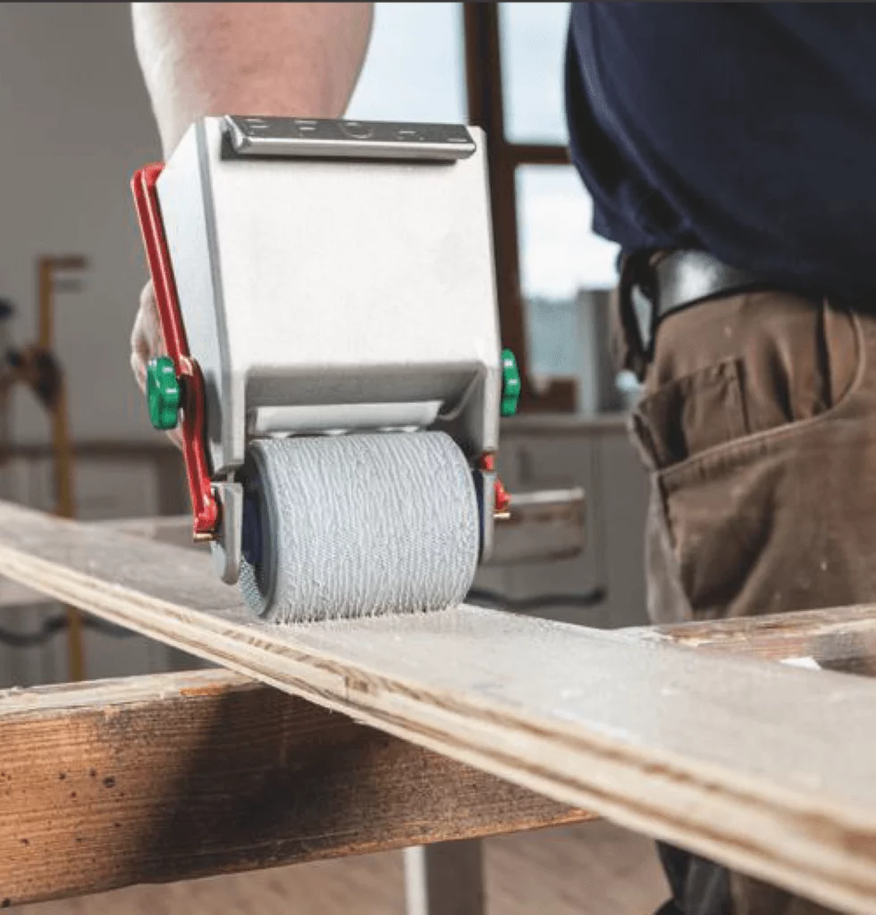 Adhesive roller applying glue to a wooden board